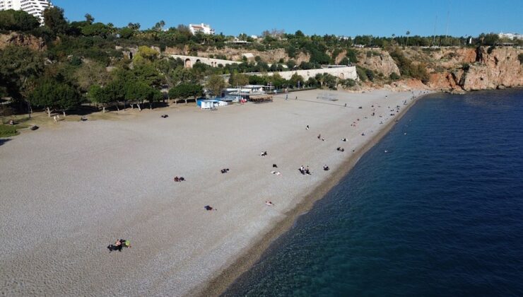 Antalya’da güneşli hava keyfi: Denize girip güneşlendiler