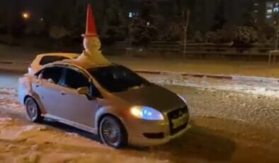 Bursa’da bir sürücü otomobilinin tavanına kardan adam yaptı