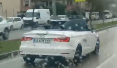 Bursa’da milyonluk arabada ıslanmamak için şemsiye açtı