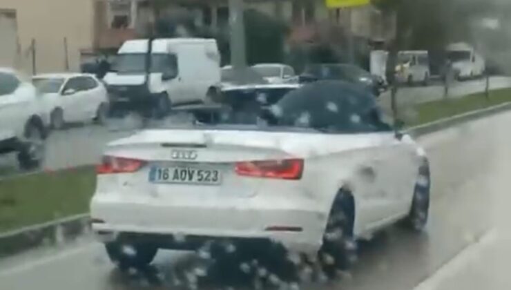 Bursa’da milyonluk arabada ıslanmamak için şemsiye açtı