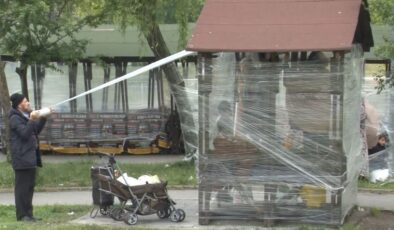 Geceyi sokakta geçiren İstanbullular soğuktan korunmak için parkları streçle kapladı