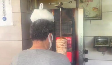 Hatay’da sıcaktan bunalan dönerci ustası başına buz torbası koydu
